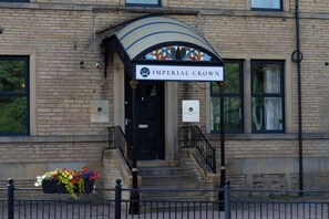 A building with a sign reading "Imperial Crown" above the entrance, featuring a brick facade and a black door. - The Imperial Crown Hotel (Halifax)