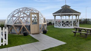 A gazebo with a white frame and a glass dome structure with a wooden door. - Kingscliff Hotel (Clacton-on-Sea)