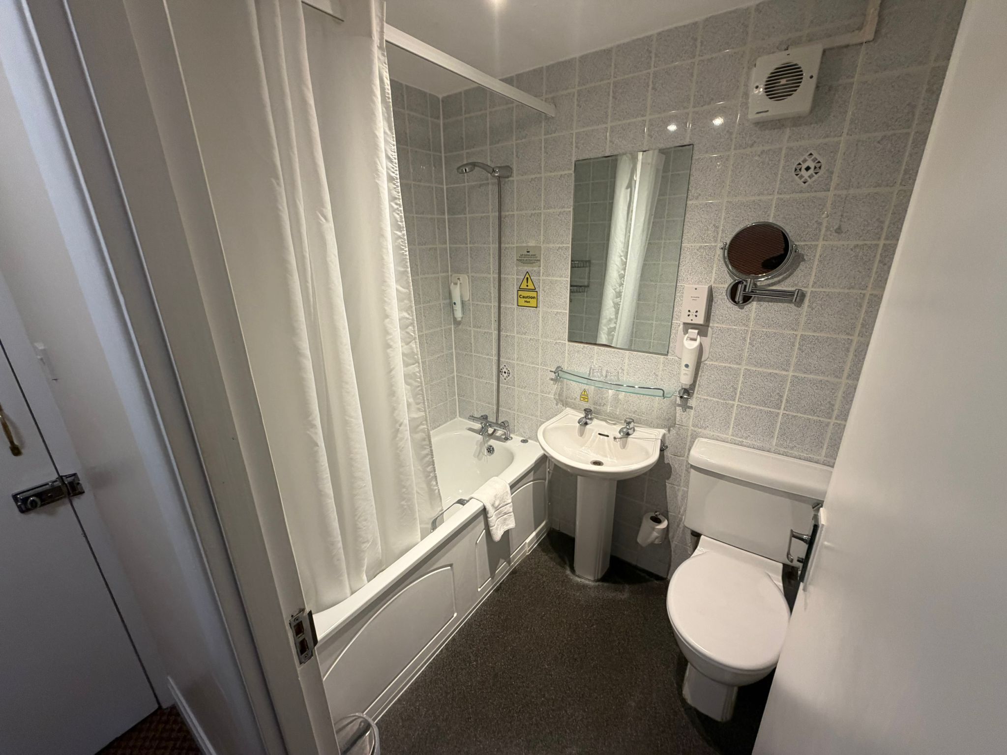 Een moderne badkamer met een bad, een wastafel en een toilet.