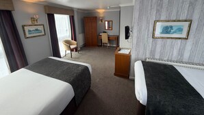 A hotel room with two beds, a desk, a chair, a wardrobe, and a bathroom. - The Raven Hotel by Greene King Inns (Hook)
