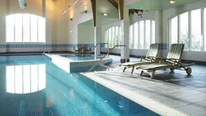 An indoor swimming pool with clear blue water, wooden beams on the ceiling, and large windows providing natural light. - Hollins Hall Hotel, Spa & Golf (Shipley)