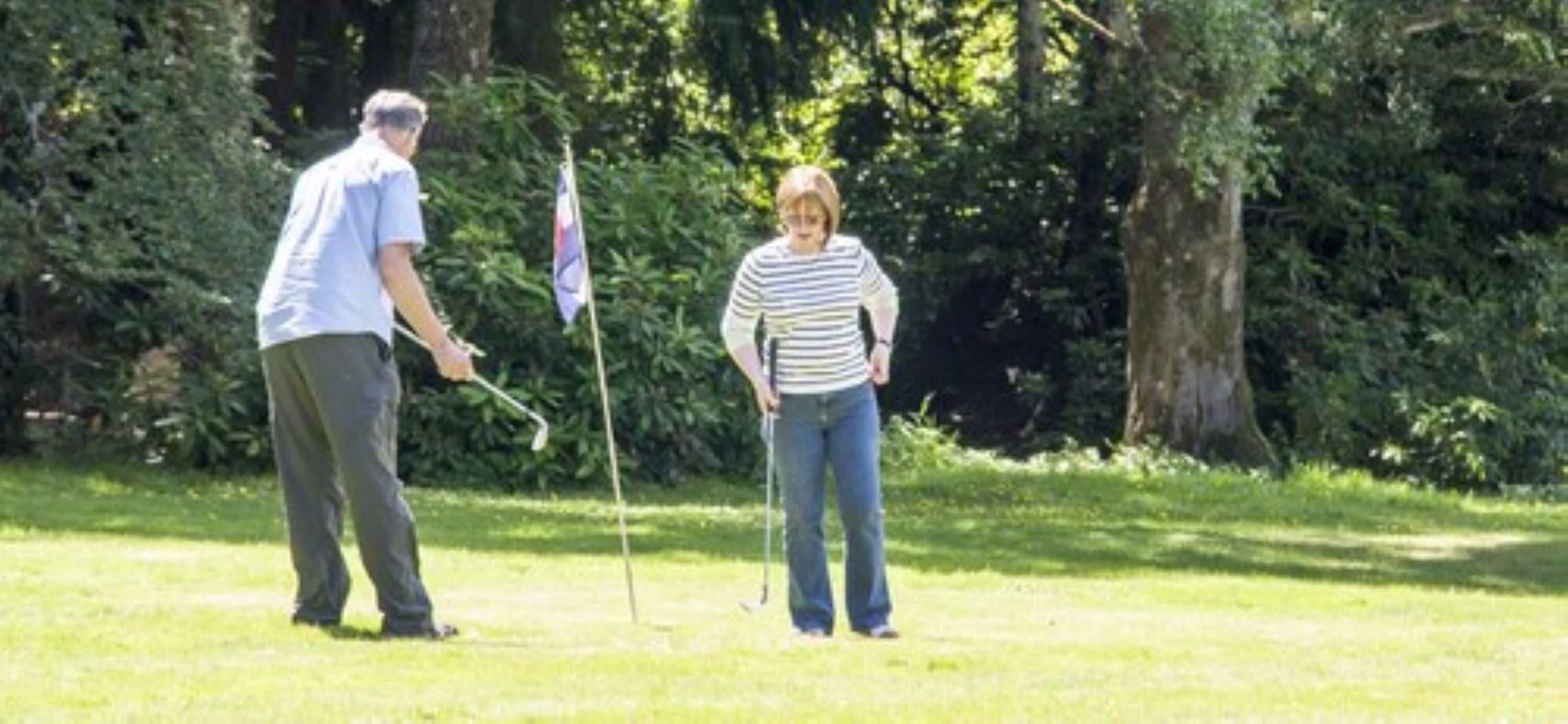 A person standing on a grassy area with trees in the background.