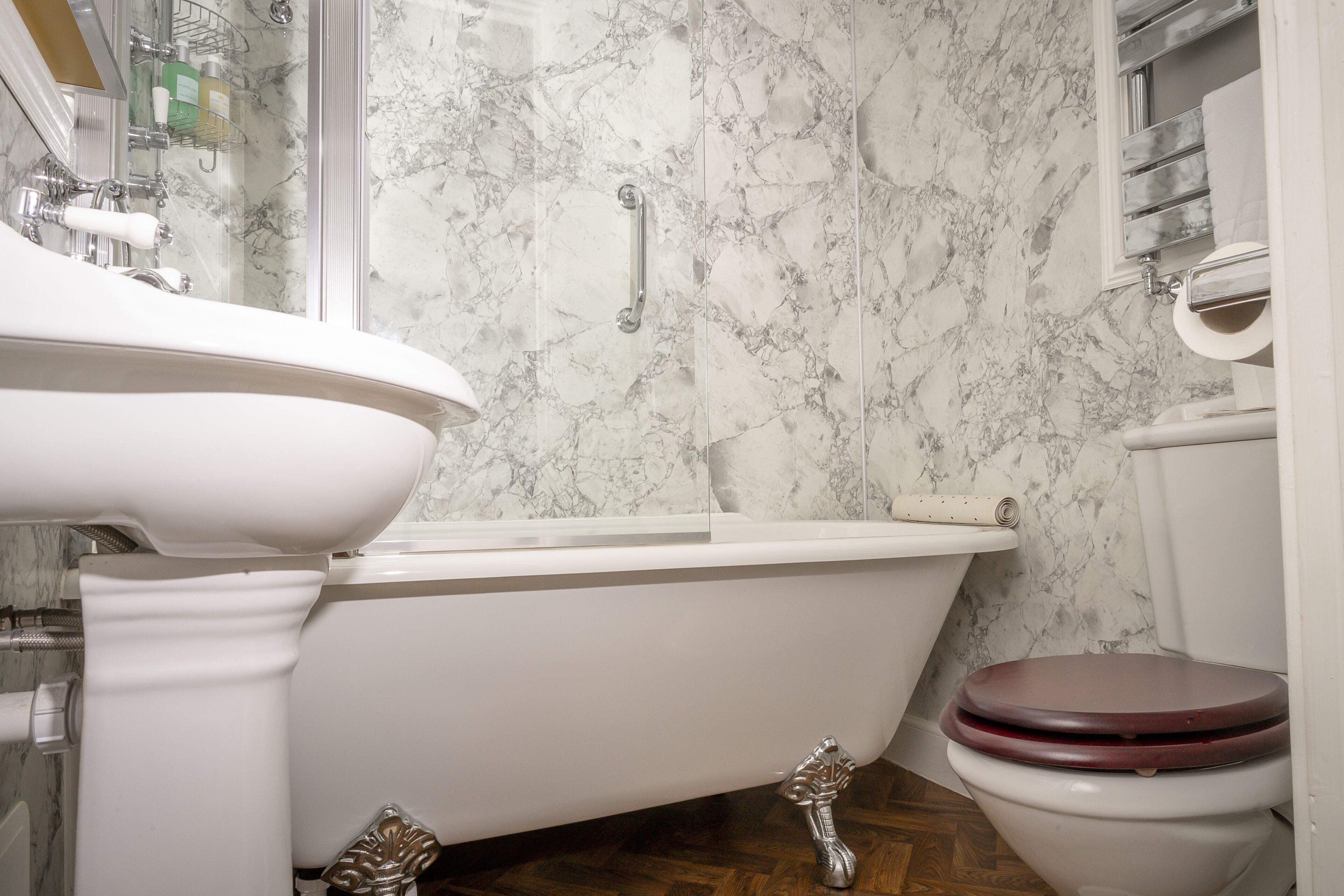A bathroom with a bathtub, toilet, and a shower area.
