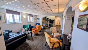 A spacious lounge area with a sofa, armchairs, a coffee table, and a staircase leading to another level. - Quality Hotel Coventry (Coventry)