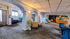 A hotel lobby with a reception desk, seating areas, and a staircase. - Quality Hotel Coventry (Coventry)