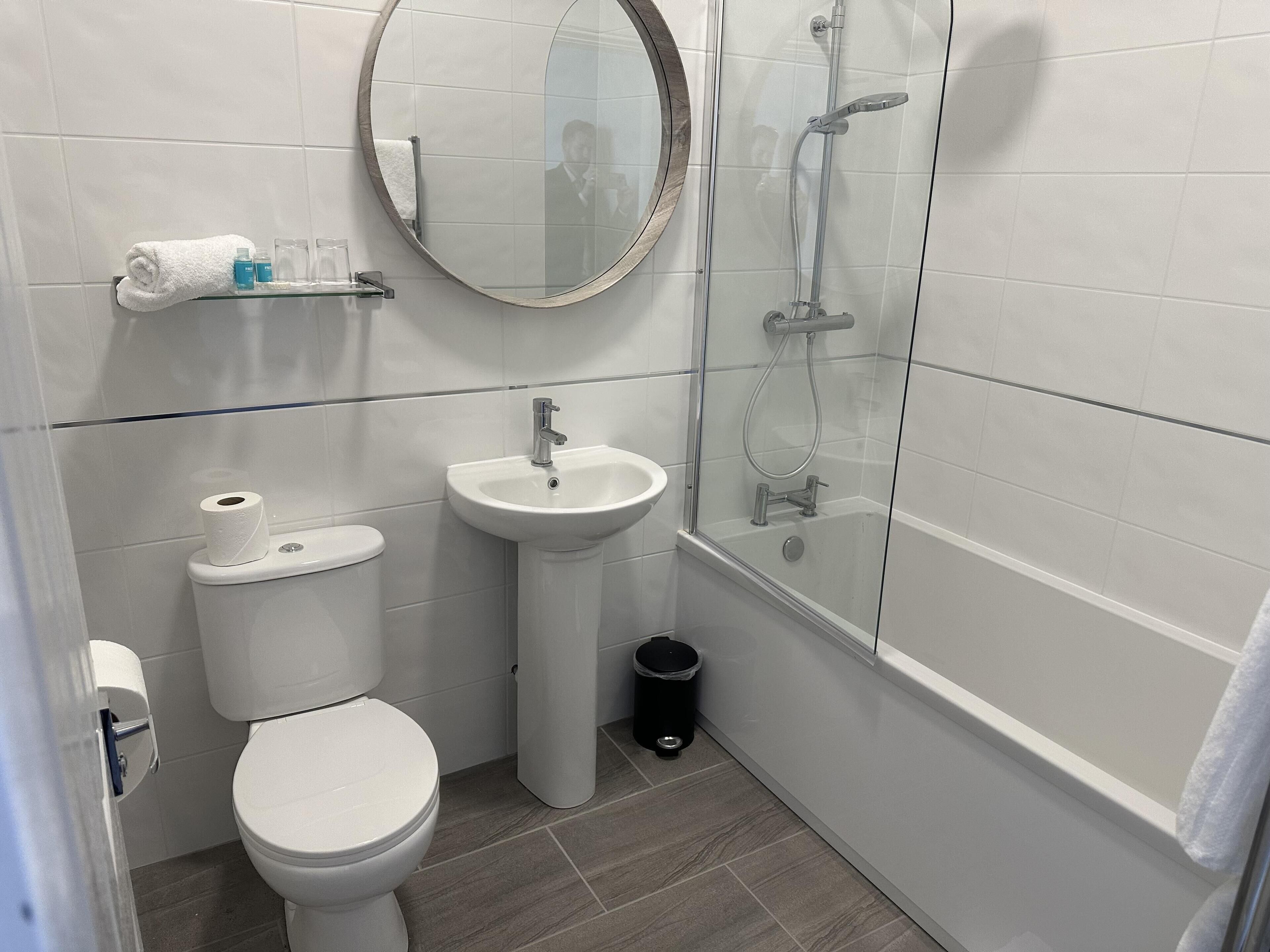Un baño con inodoro, lavamanos y ducha.