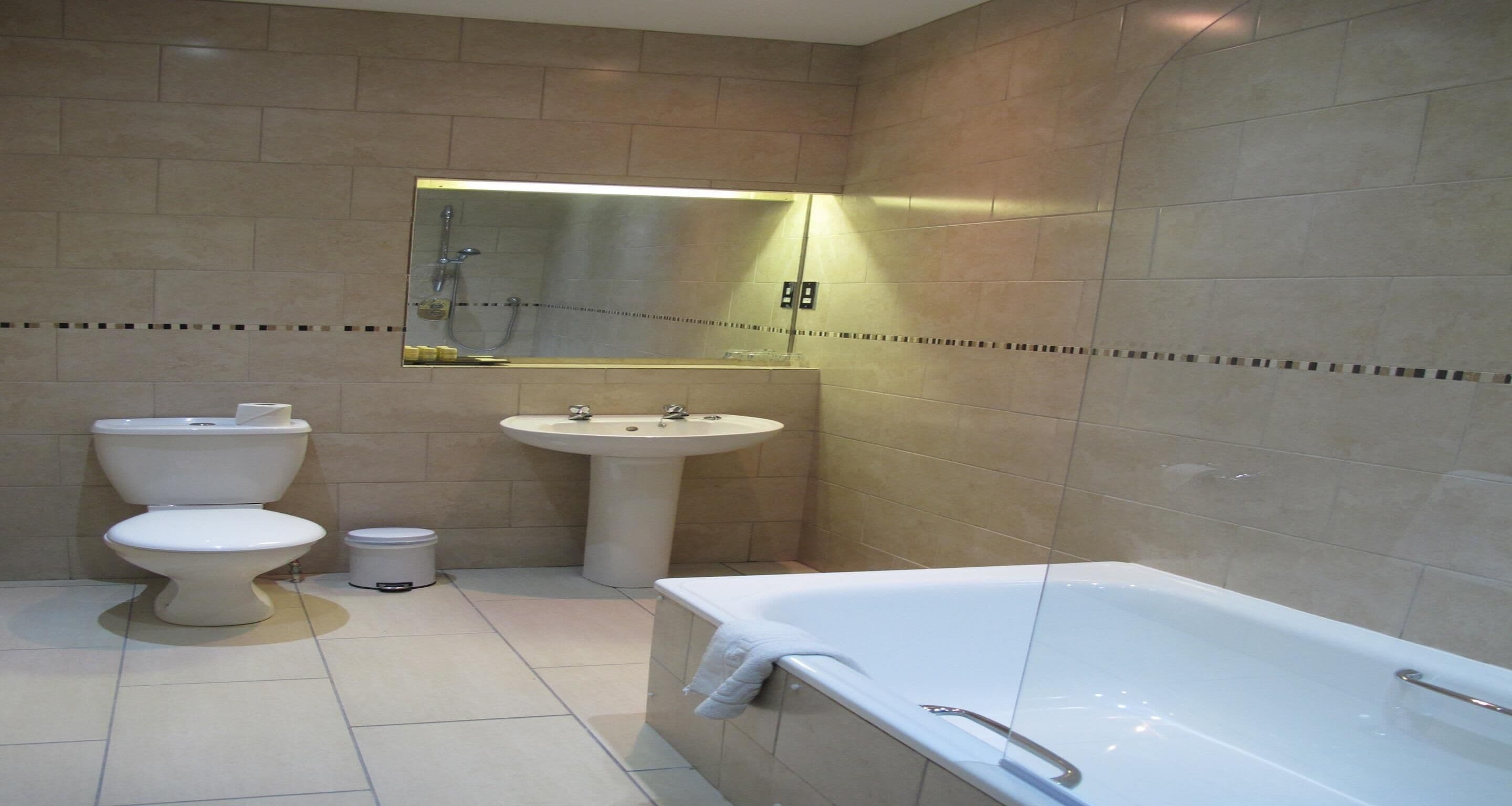 A bathroom with a toilet, sink, and bathtub.