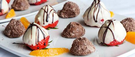 Un plato de postre con trufas de chocolate y fresas.