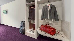Una exposición de ropa que incluye un traje, un bolso rojo y un par de zapatos.