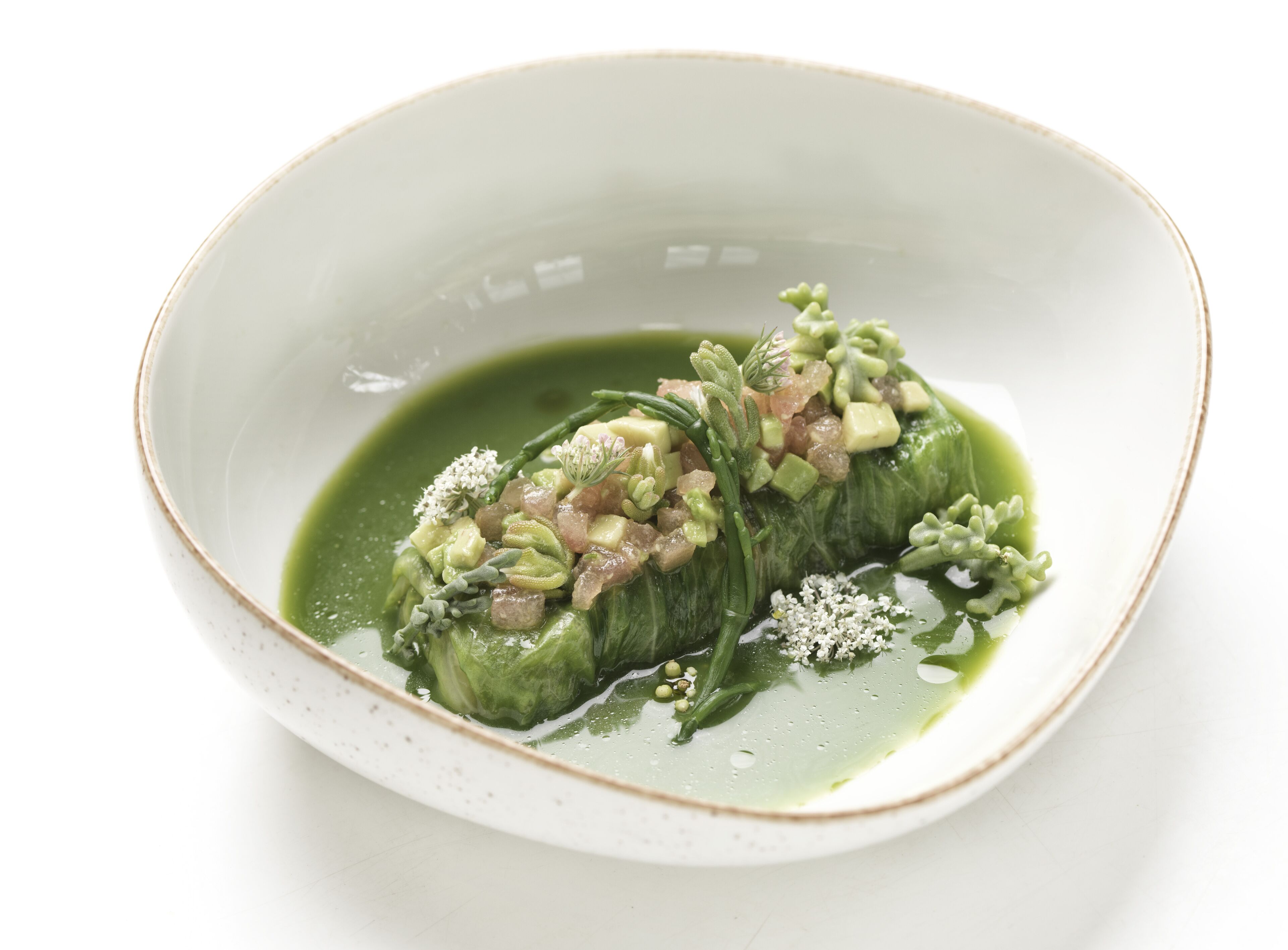 Una ciotola bianca con salsa verde e verdure ripiene.