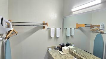 A modern bathroom with a granite countertop, a sink, a mirror, and a towel rack.
