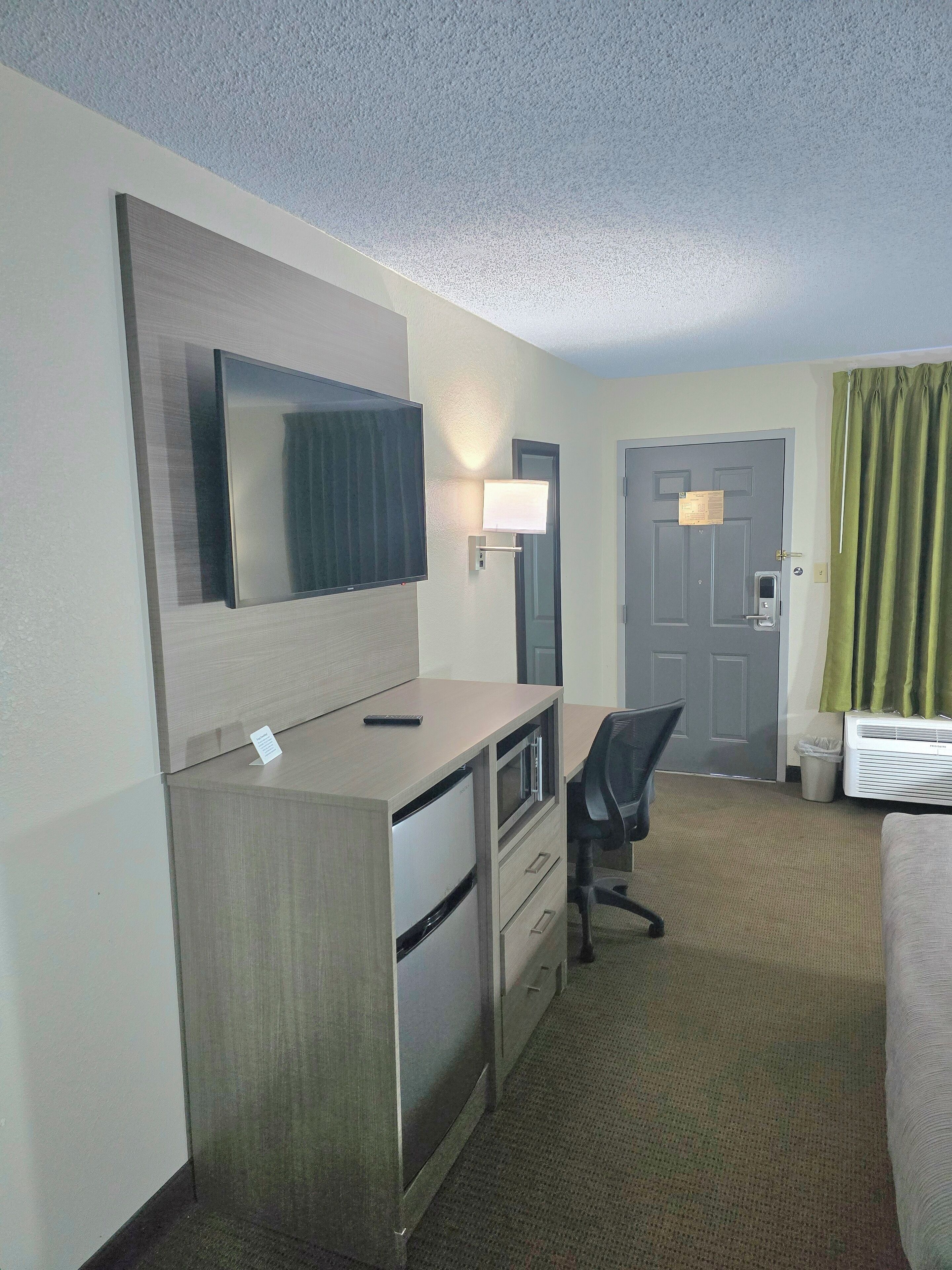 Een hotelkamer met een bureau, stoel en bed.