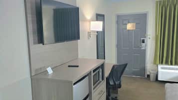 Een hotelkamer met een bureau, stoel en bed.