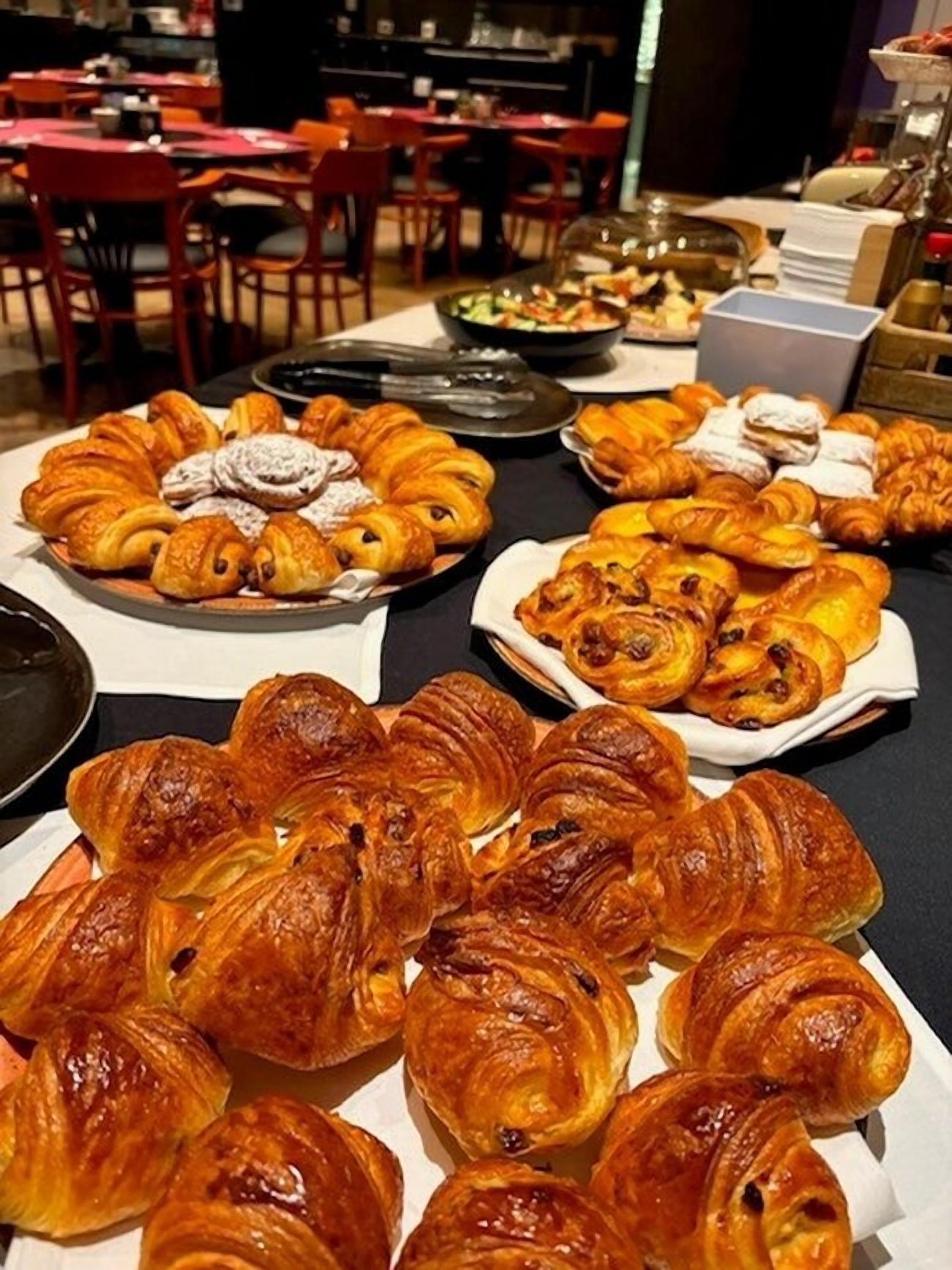 A buffet table with various pastries and desserts.