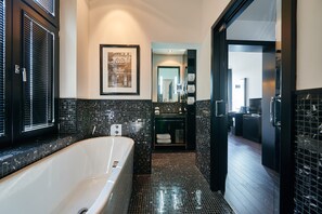 A modern bathroom with a freestanding bathtub, black tiled walls, and a framed picture on the wall. - Boutique Villa am Ruhrufer Retreat (Muelheim an der Ruhr)