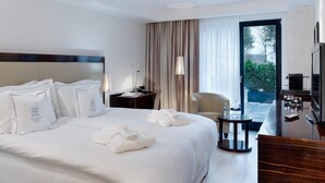 A hotel room with a large bed, a desk, a chair, and a view of the outdoors. - Boutique Villa am Ruhrufer Retreat (Muelheim an der Ruhr)