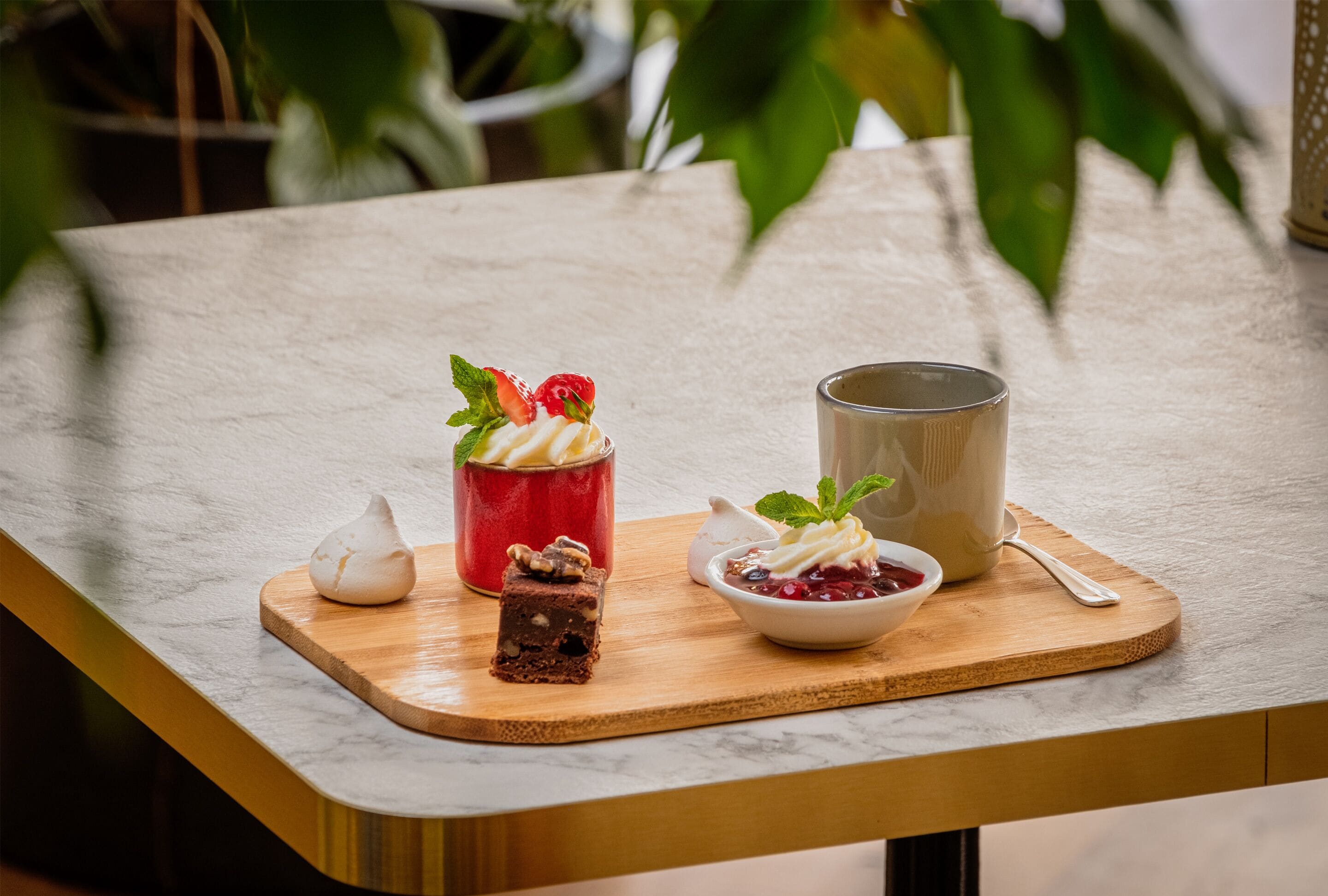 Un plateau de desserts présentant une variété de douceurs, posé sur un comptoir en marbre.