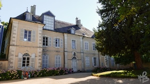 A historic building with a symmetrical facade, large windows, and a central entrance.