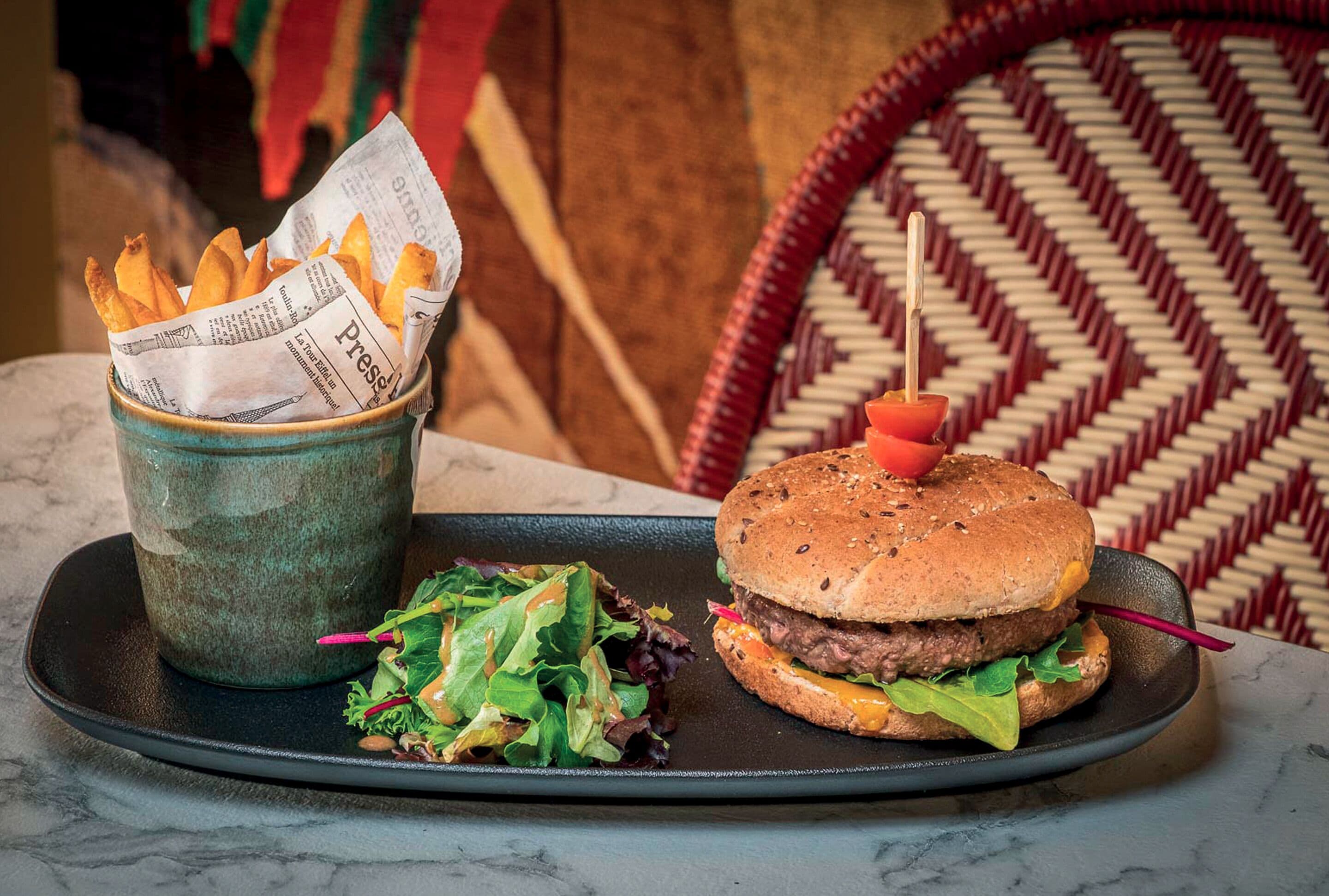 Un plato con una hamburguesa, papas fritas y una ensalada.