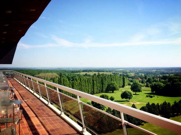 Un balcon avec vue sur un terrain de golf et la végétation environnante.