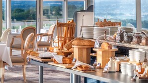 A breakfast buffet with bread, pastries, and condiments.