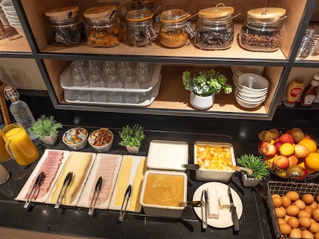 A breakfast buffet with various food items, utensils, and condiments.. Ibis Orleans La Chapelle Saint Mesmin