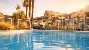 Een seizoensgebonden buitenzwembad, parasols voor strand/zwembad