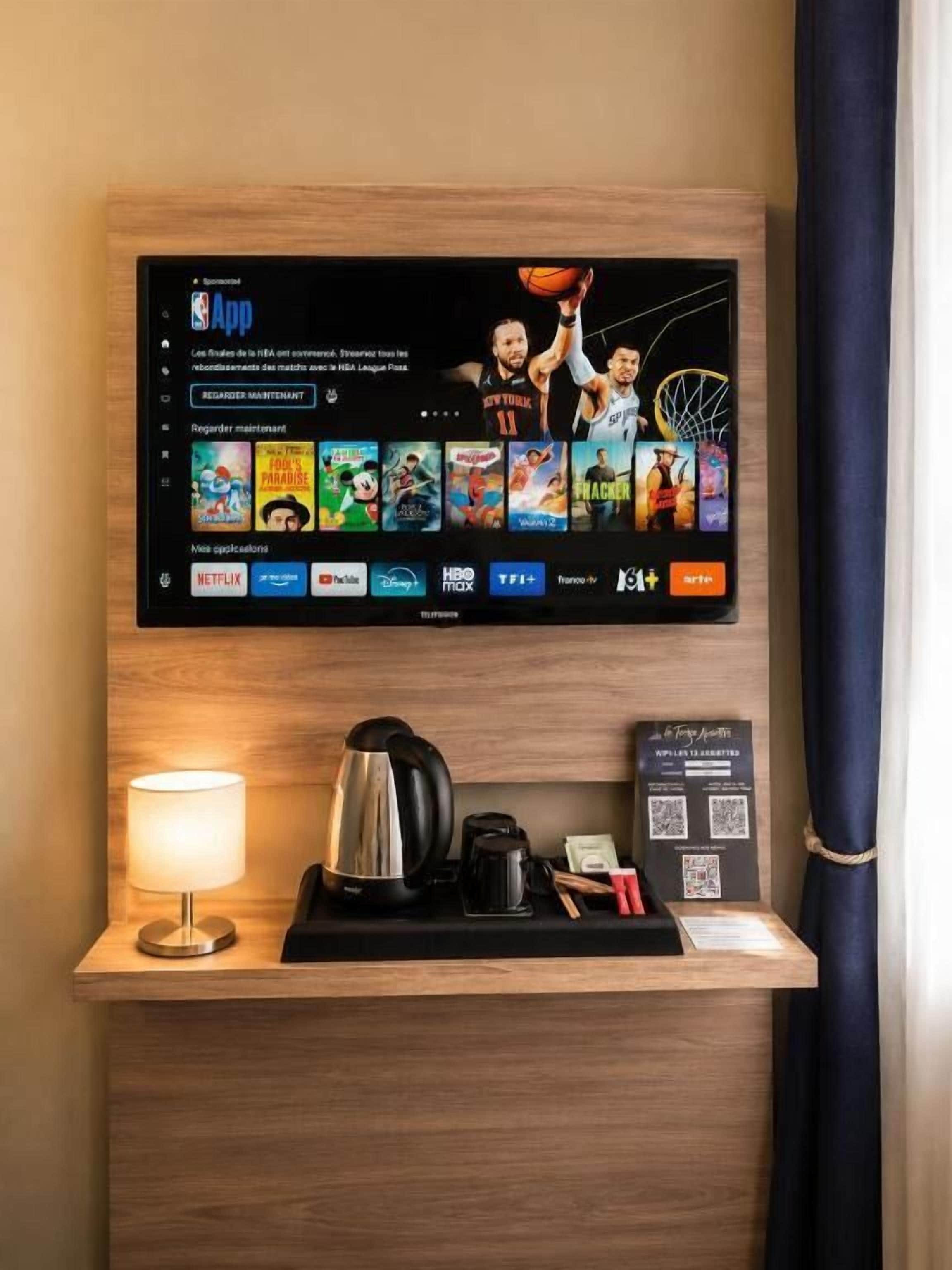 Televisor montado en una pared de madera mostrando la aplicación de la NBA y otros servicios de transmisión.