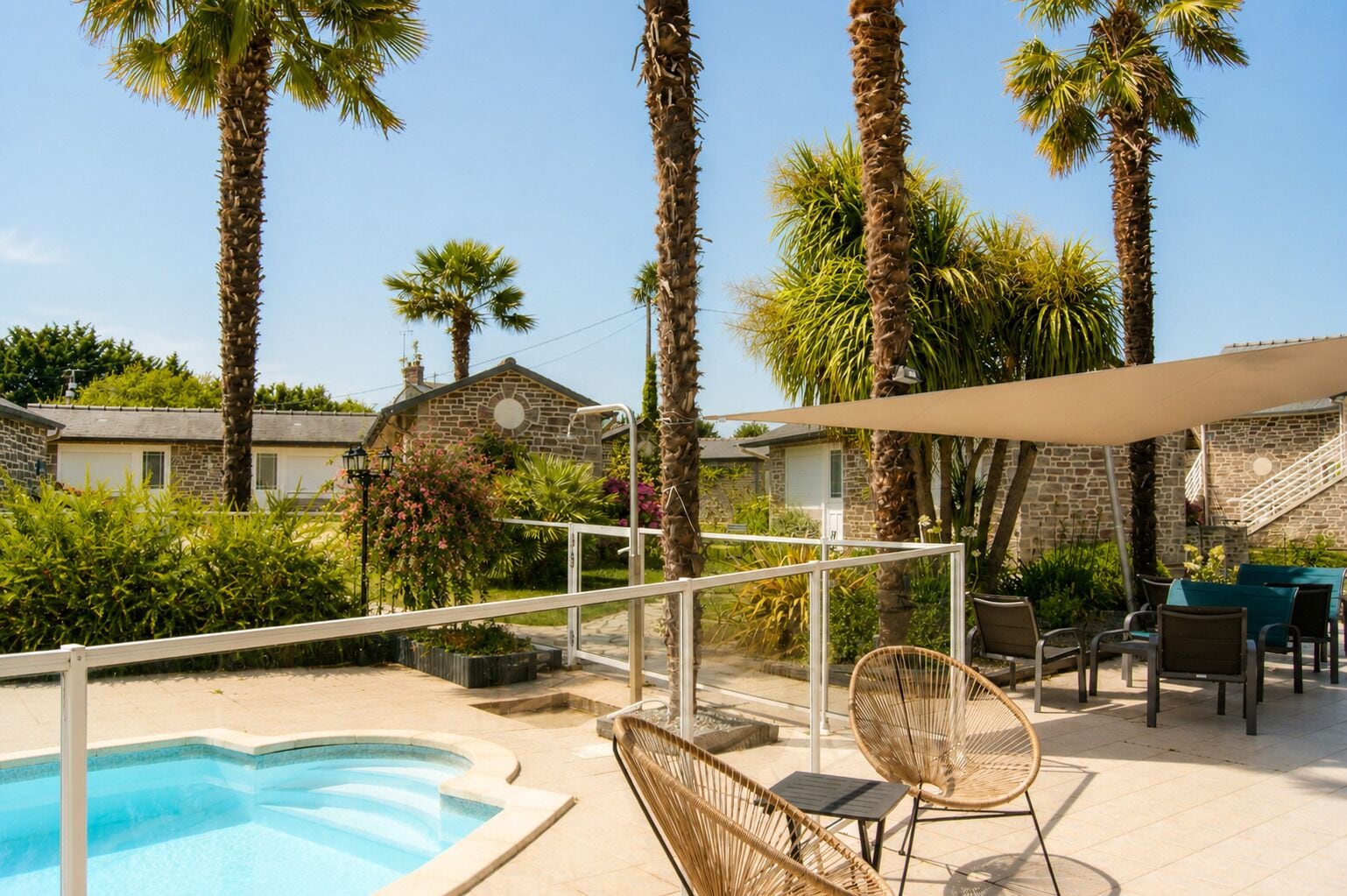 A poolside area with a pool, lounge chairs, and palm trees.