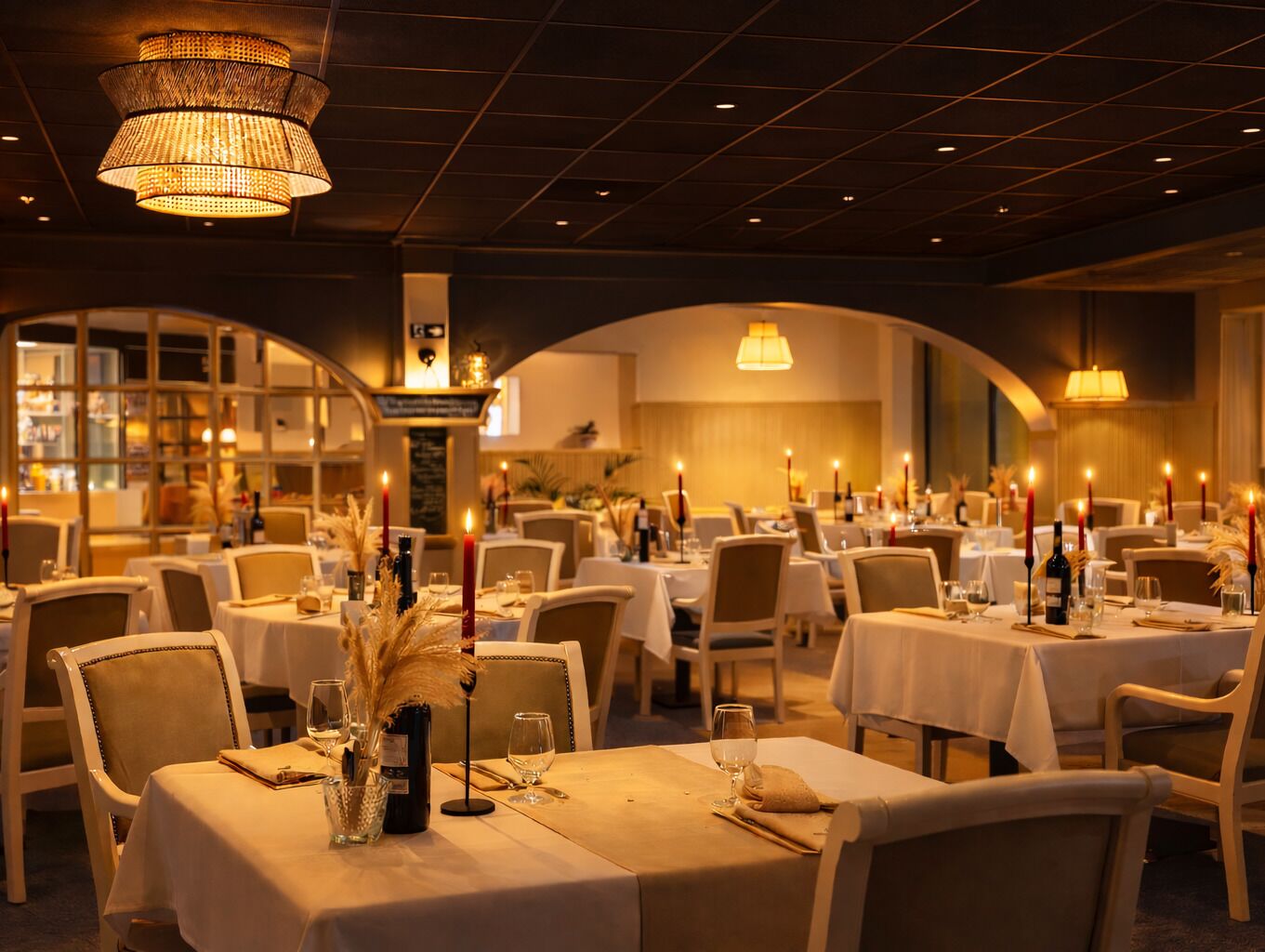 A restaurant with multiple tables, candles, and a warm ambiance.