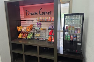 Una exhibición de snacks con diversos alimentos envasados y un dispensador de bebidas.