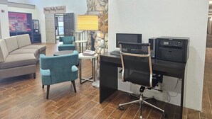 A modern office space with a desk, chairs, a computer, and a printer.