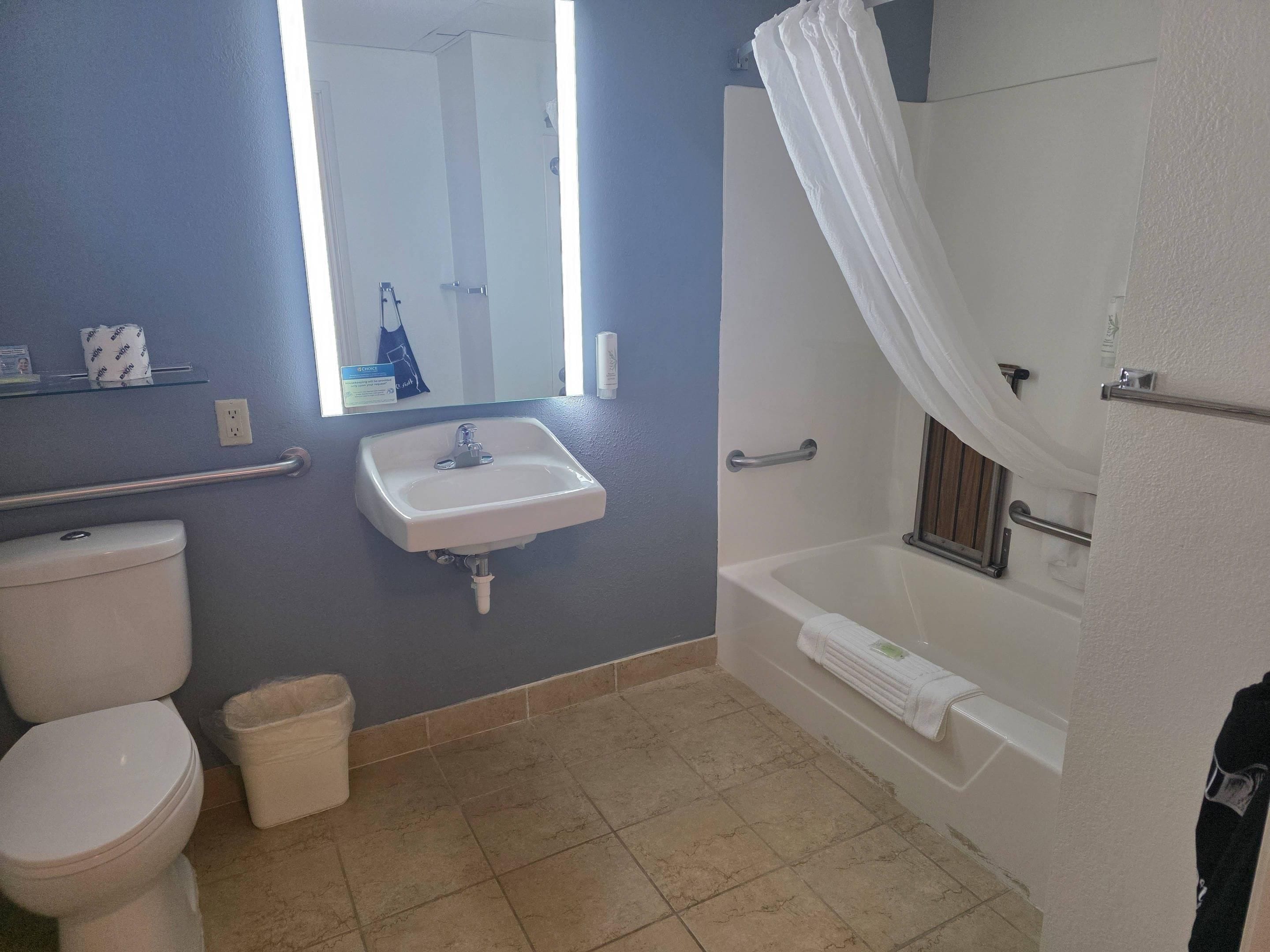 Une salle de bain avec des toilettes, un lavabo et une baignoire.
