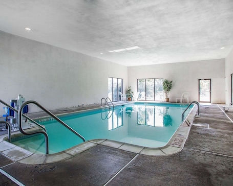 Una piscina cubierta, tumbonas. Quality Inn Midway