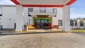 A gas station with a white building, red accents, and a green entrance.