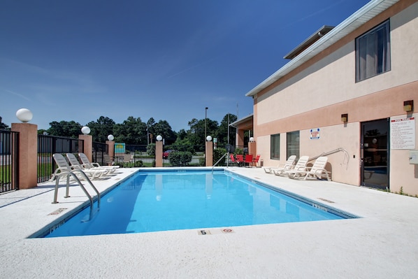Piscine extérieure en saison, chaises longues