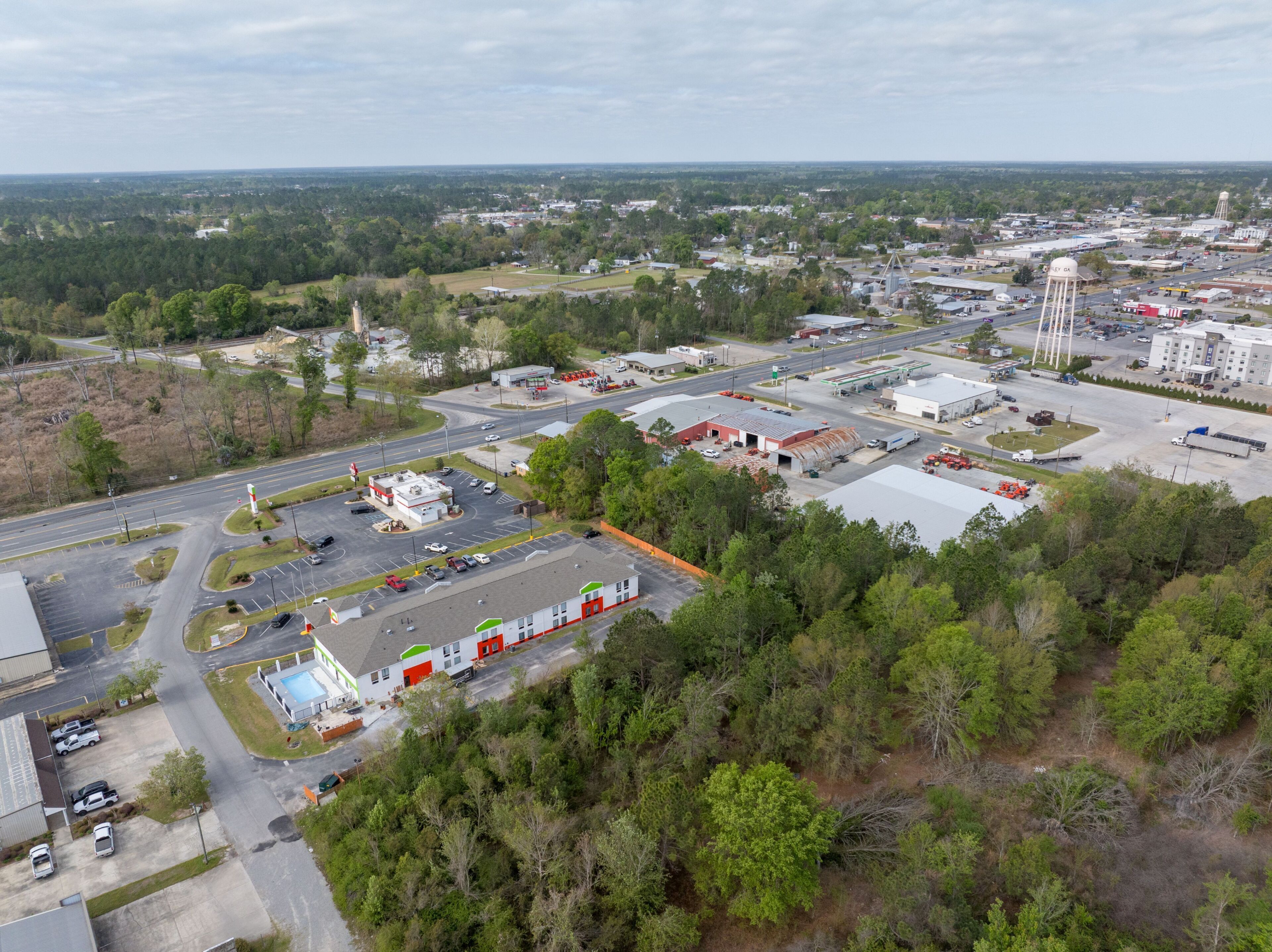 An aerial view of a commercial area with industrial buildings, a parking lot, and a water tower.