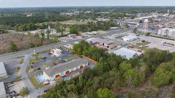 An aerial view of a commercial area with industrial buildings, a parking lot, and a water tower.