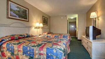 Habitación de hotel con una cama grande, un televisor en una cómoda y un pasillo que conduce a otra habitación.