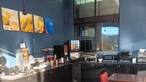 Un restaurant moderne doté d’un bar, de tables et d’une grande fenêtre offrant une vue panoramique.