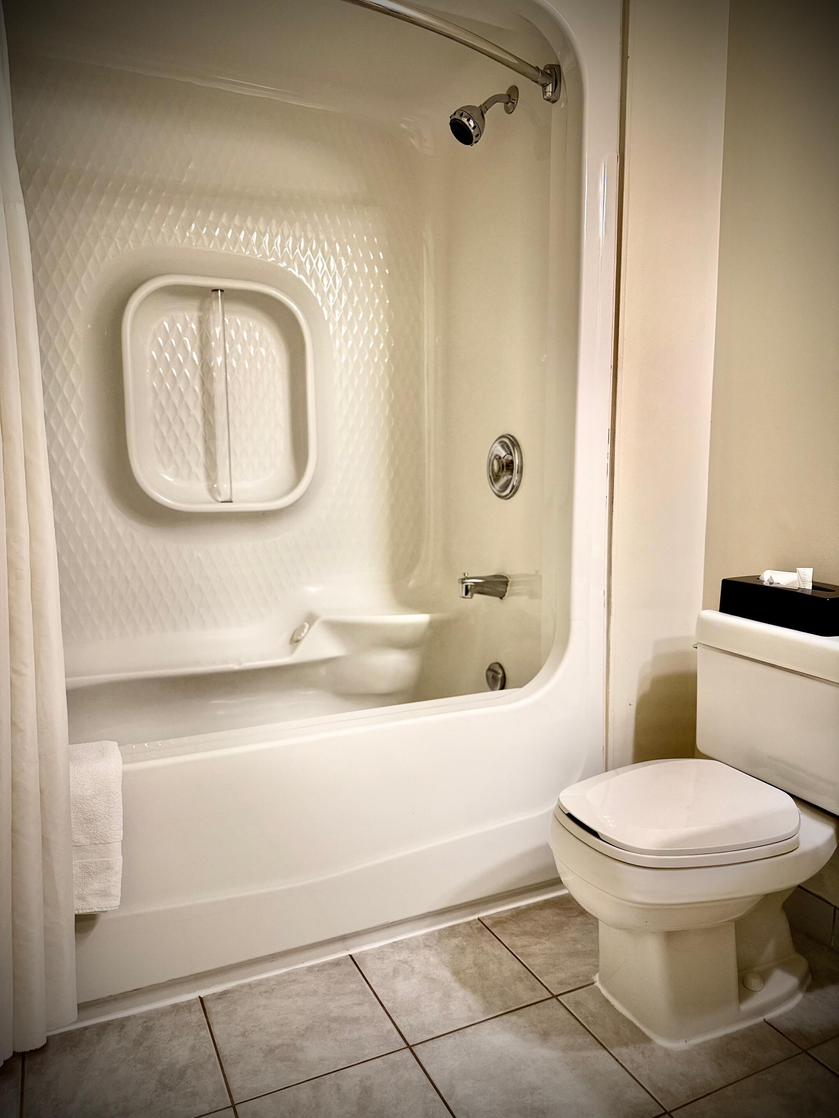 A bathroom with a bathtub, toilet, and a small sink.