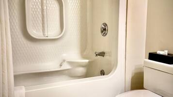 A bathroom with a bathtub, toilet, and a small sink.