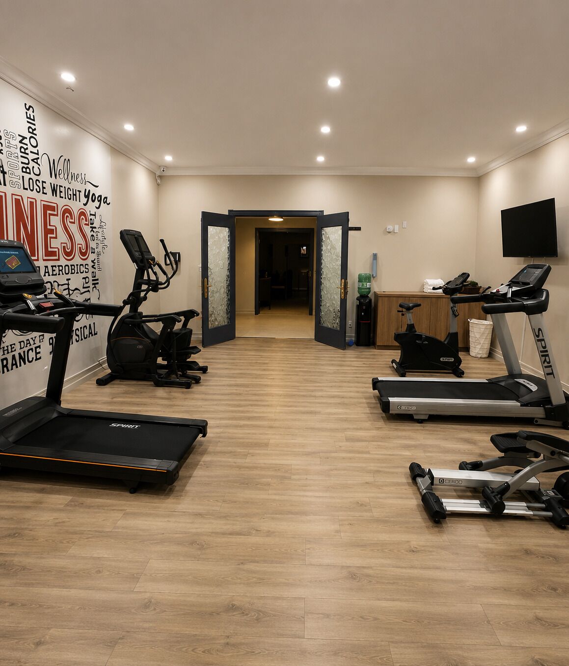 A gym with treadmills, stationary bikes, and exercise equipment.
