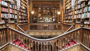 A grand library with multiple levels, ornate wooden railings, and a central staircase. - Golden Tulip Porto Gaia Hotel (Vila Nova de Gaia)