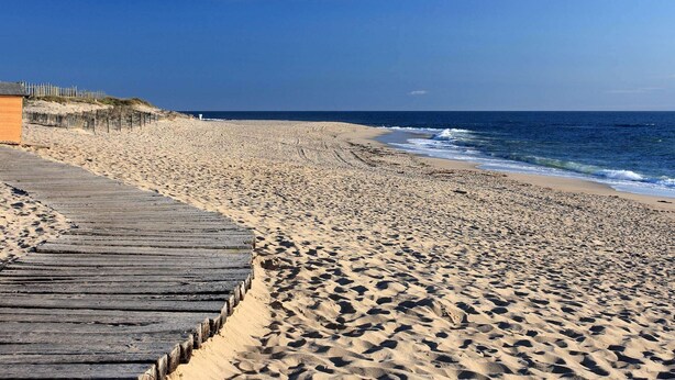 A sandy beach with a wooden boardwalk leading to a dune area. - Golden Tulip Porto Gaia Hotel (Vila Nova de Gaia)