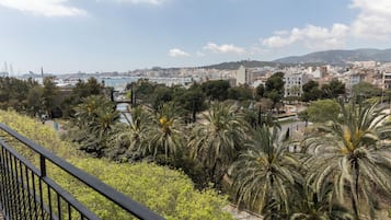 Un balcón con vistas a un paisaje urbano, que incluye edificios y un puerto deportivo.
