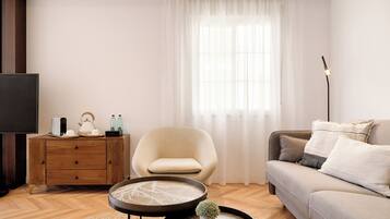 A modern living room with a sofa, armchair, coffee table, and a TV.