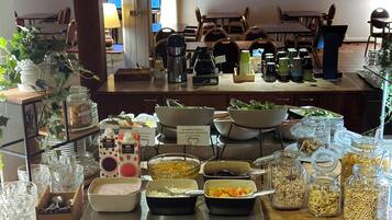 Una mesa de buffet con diversos alimentos y utensilios.