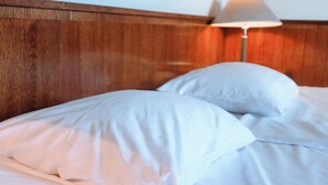 A bed with white bedding and a wooden headboard. - Hotel Sommelo (Kouvola)