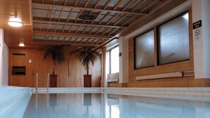 A swimming pool with wooden walls and a ceiling with wooden beams. - Hotel Sommelo (Kouvola)